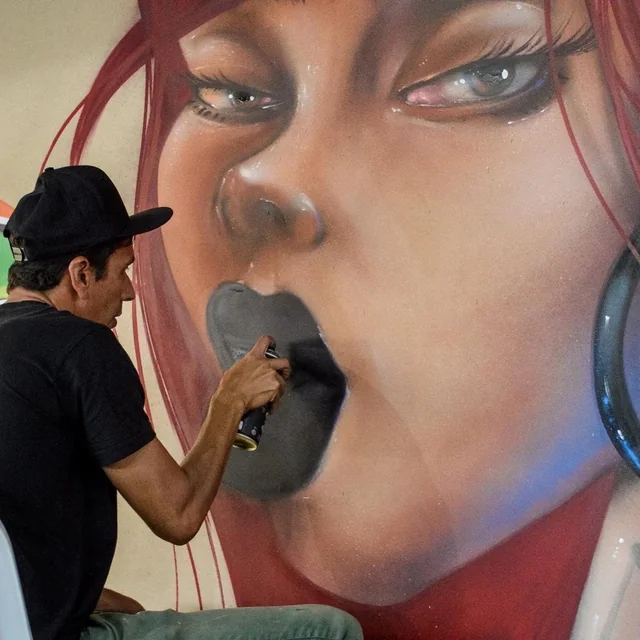 Artista pintando um mural de graffiti